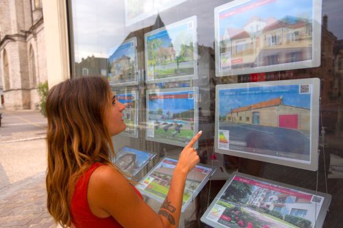 personne qui regarde les annonces vitrine de l'agence RESIDE Immobilier